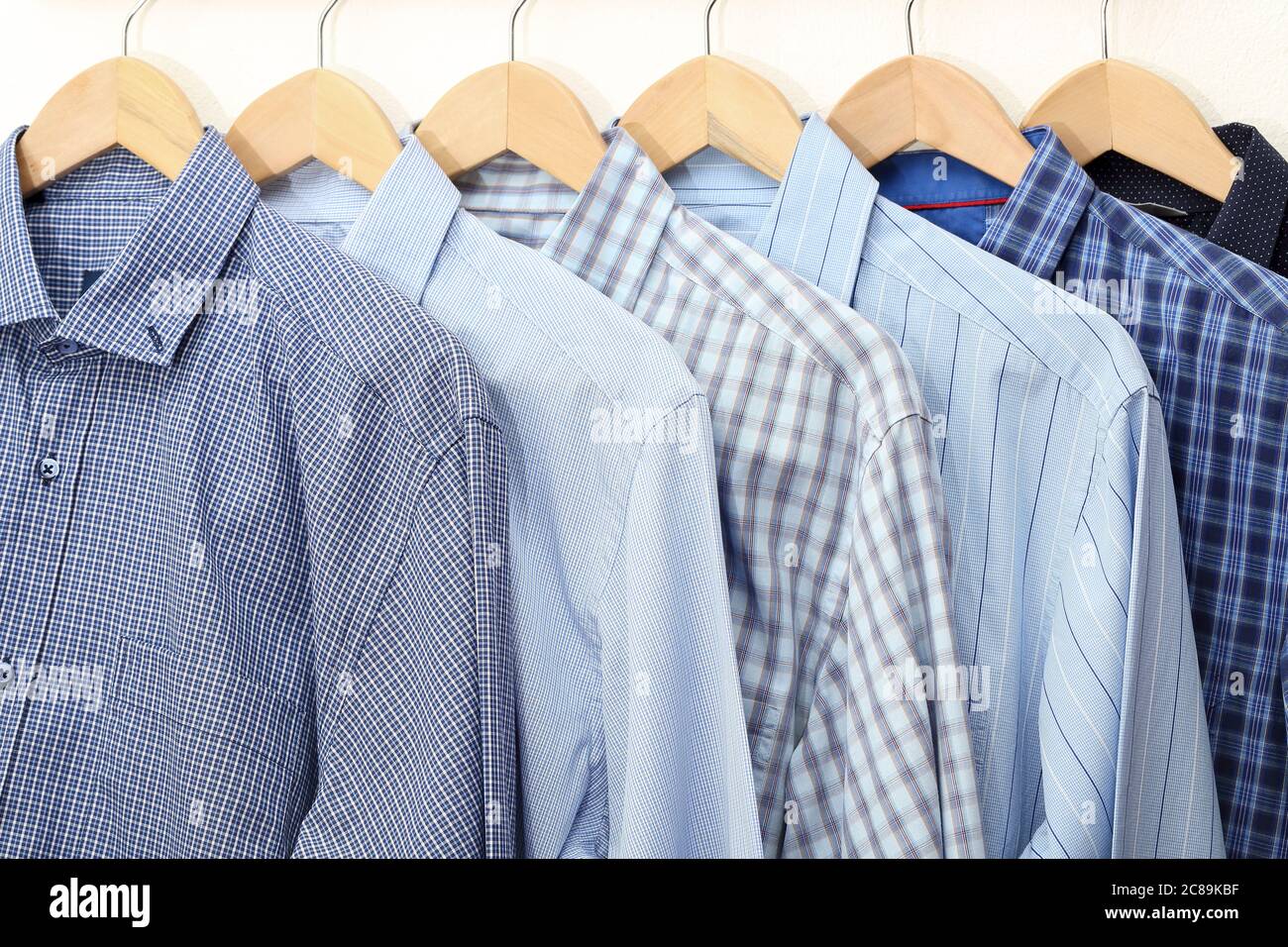 Kollektion von blauen Hemden auf Kleiderbügel, Herrenmode Stockfoto