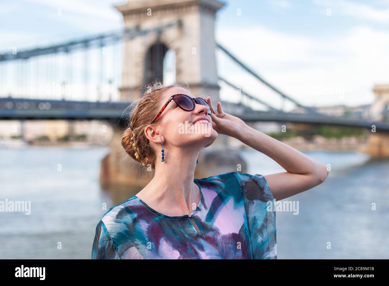 Glückliche junge Frau, die beim Sightseeing in Budapest, Ungarn aufschaut Stockfoto