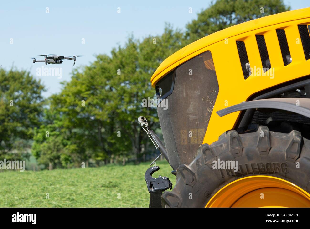 Fliegen Sie eine DJI Drohne und Filmen Sie einen gelben Traktor, Scottish Borders. Stockfoto