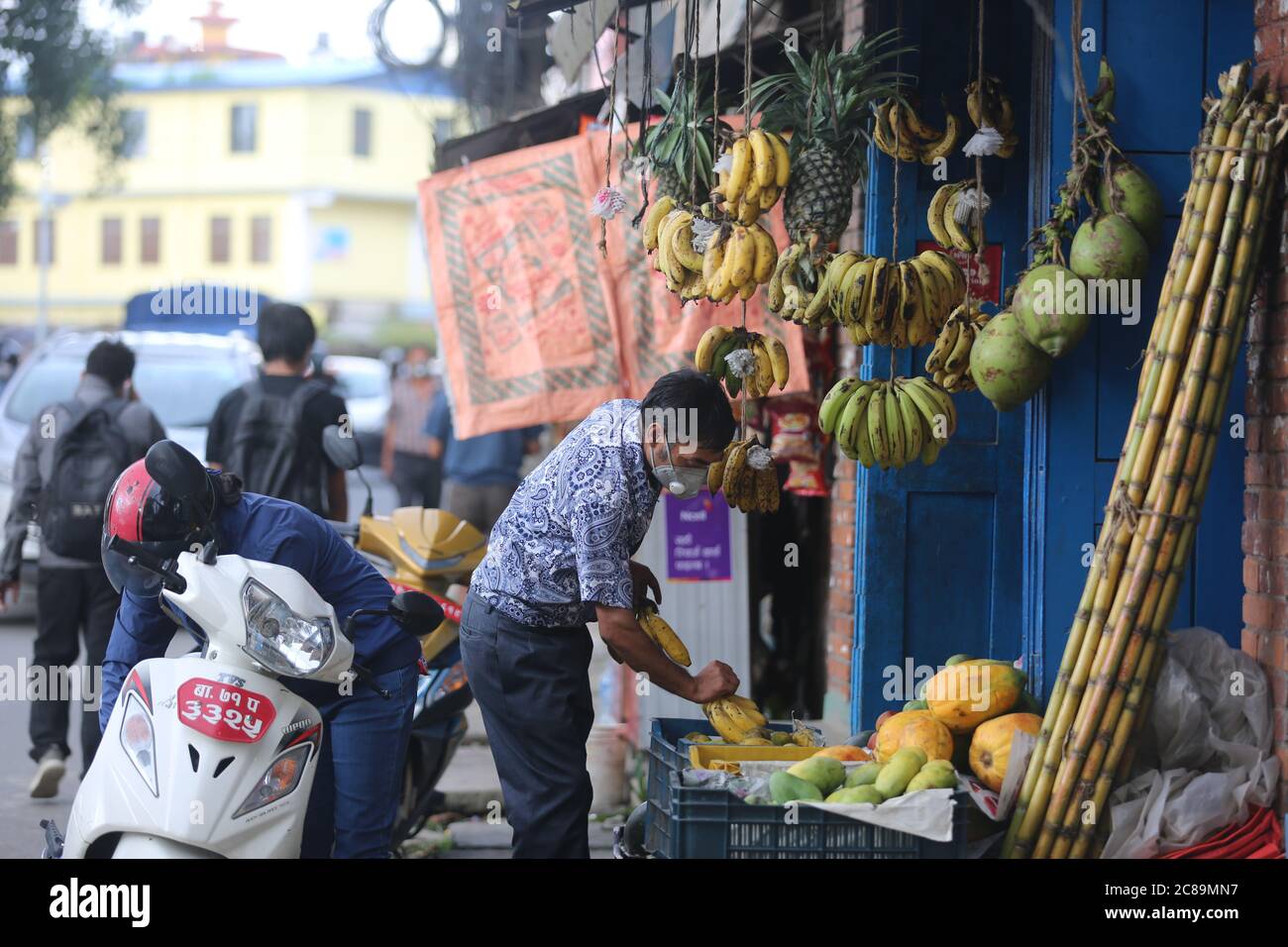 Kathmandu. Juli 2020. Ein Mann arrangiert am 22. Juli 2020 an einem Obststand in Kathmandu, Nepal, Bananen. Die nepalesische Regierung hat beschlossen, die fast viermonatige Sperre formell zu beenden, so dass fast alle wirtschaftlichen Aktivitäten funktionieren, da das Land Zeugen sinkender Zahl neuer COVID-19-Fälle in den letzten Tagen ist, sagte ein hochrangiger Minister des Kabinetts. Quelle: Zhou Shengping/Xinhua/Alamy Live News Stockfoto