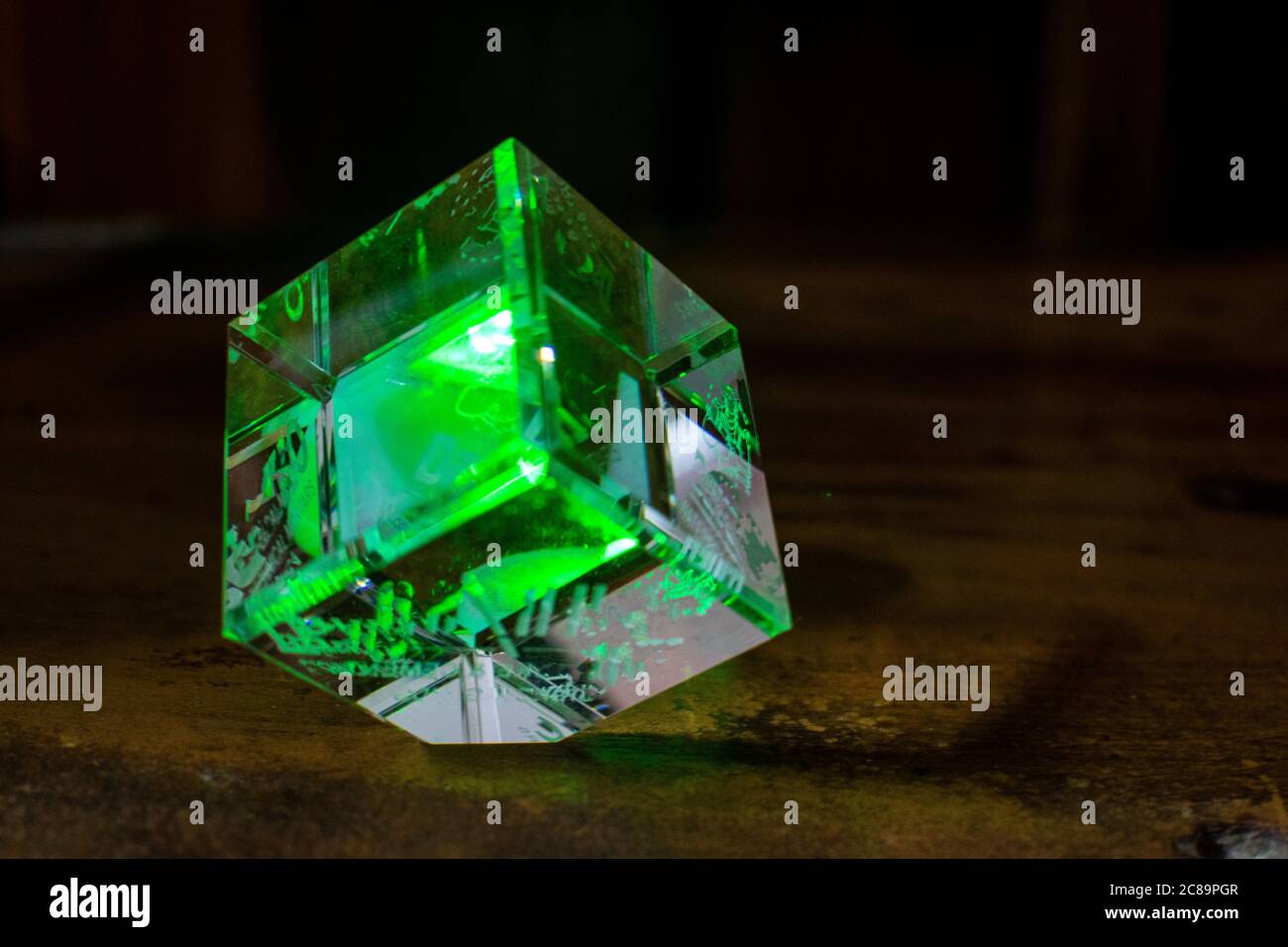 Ein Glaswürfel, der grünes Licht reflektiert Stockfoto