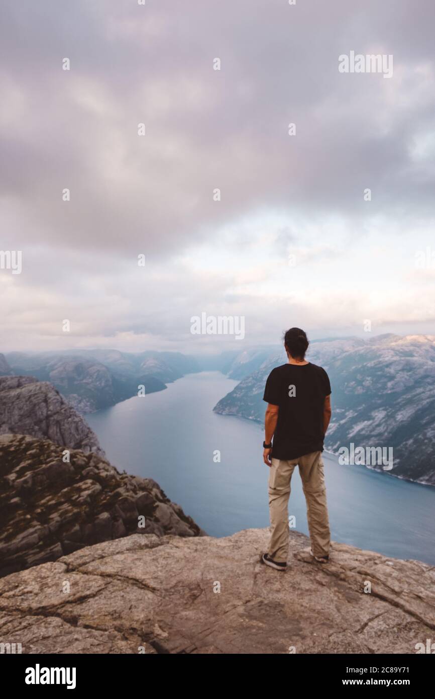 Mann, der am Rand der Klippe bei Preikestolen, Norwegen, steht Stockfoto