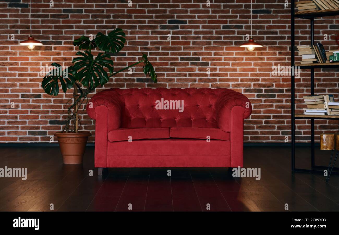 Rote klassische Couch im Loft-Stil Zimmer mit Innenpflanzen Stockfoto