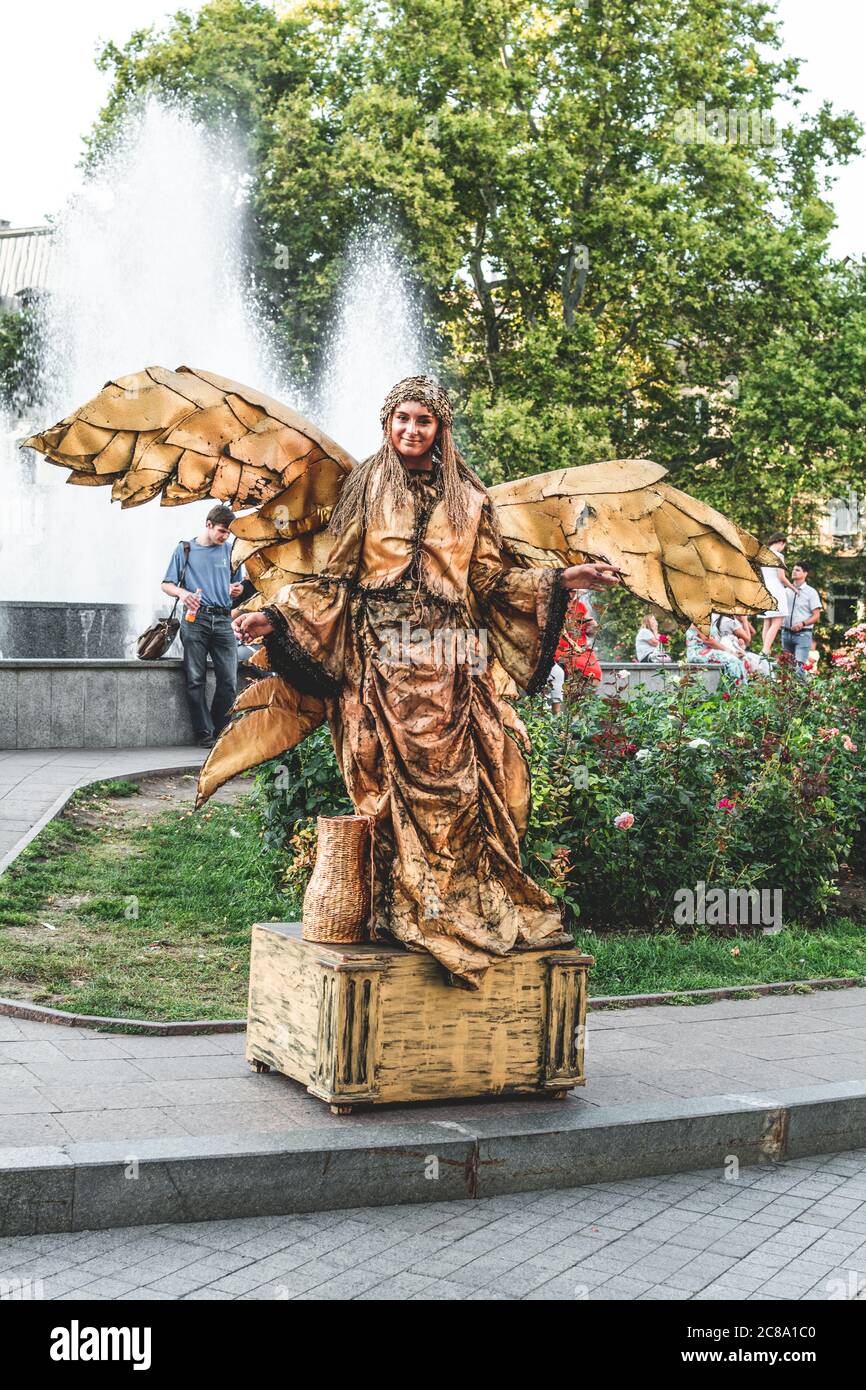 Ukraine, Odessa, Istanbul Park - 23. August 2019: Lebende Statue eines goldenen Engelsmädchens mit Flügeln im Istanbul Park in der Nähe des Odessa Handelshafens Stockfoto