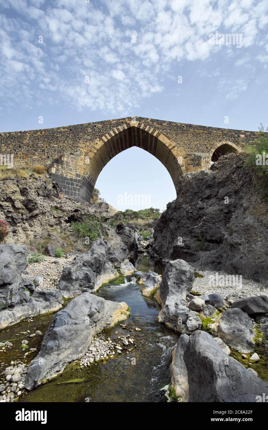 arabischer Bogen einer Brücke über den Fluss Simeto, ein Beispiel der alten sizilianischen Architektur Stockfoto