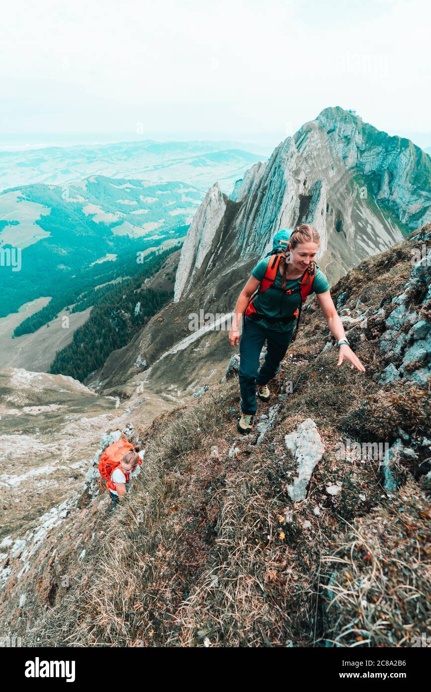 Zwei Bergsteigerinnen erklimmen in der Schweiz einen steilen Berg Stockfoto