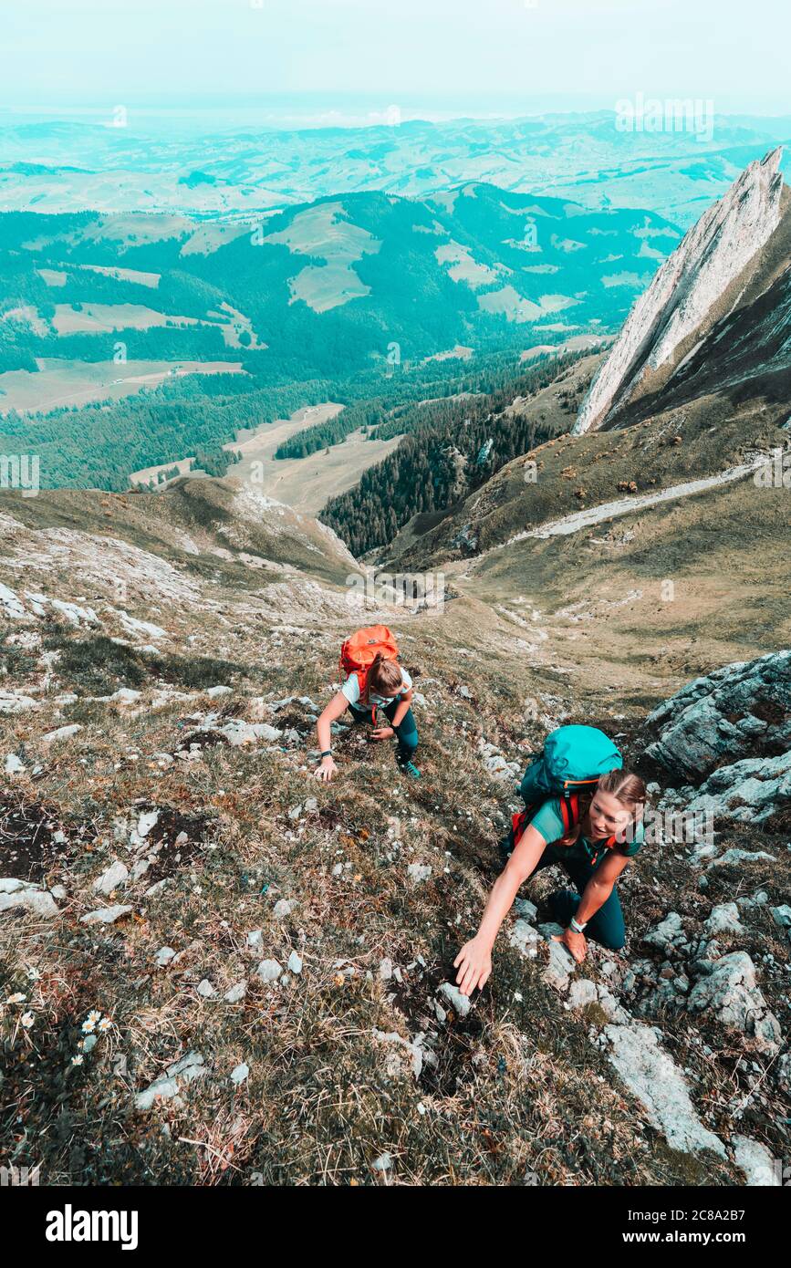 Frontaufnahme von Frauen, die in den schweizer alpen eine steile Klippe aufsteigen Stockfoto