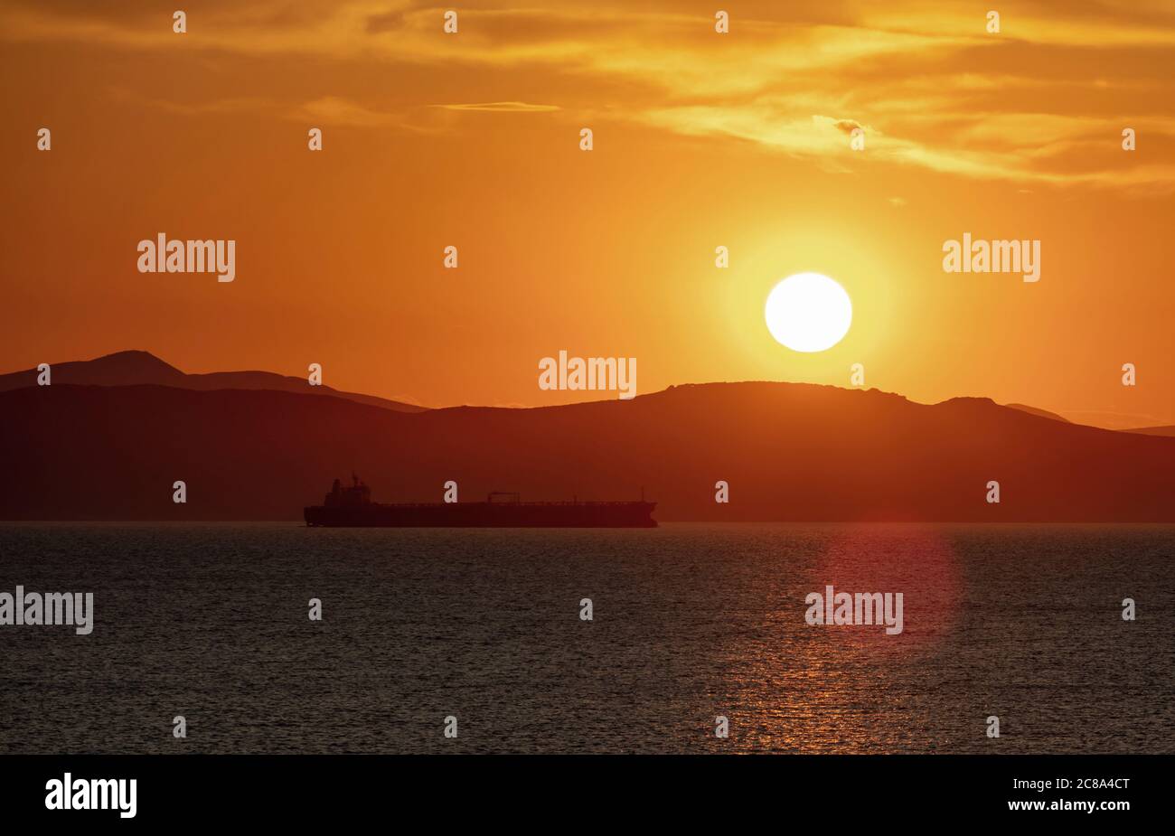 Sonnenuntergang orange Wolkenlandschaft über dem Meerwasser. Dramatische magische Sonnenaufgangslandschaft in Ägäis Griechenland. Dämmerung, Dämmerung Hintergrund. Dunkles Inselland und Orang Stockfoto