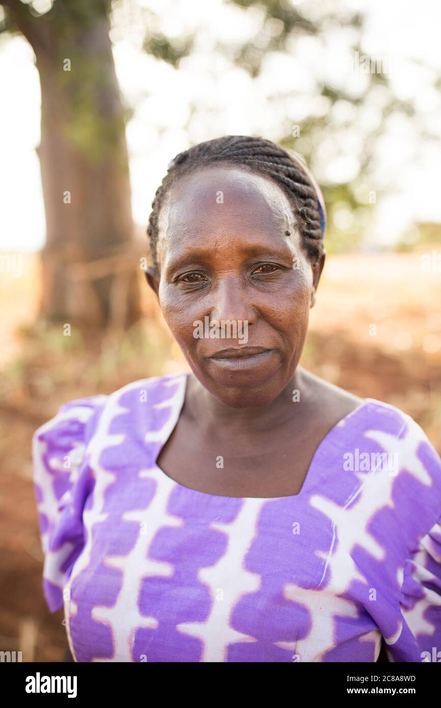 Porträt einer Frau mit einem düsteren Ausdruck in einer trockenen Landschaft im Makueni County, Kenia, Ostafrika. Stockfoto