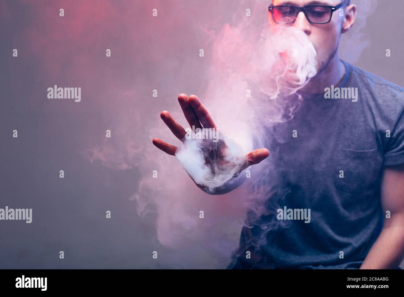 Vape Trick Ringe in der Leistung von Vaper auf rot-blauen Hintergrund  Stockfotografie