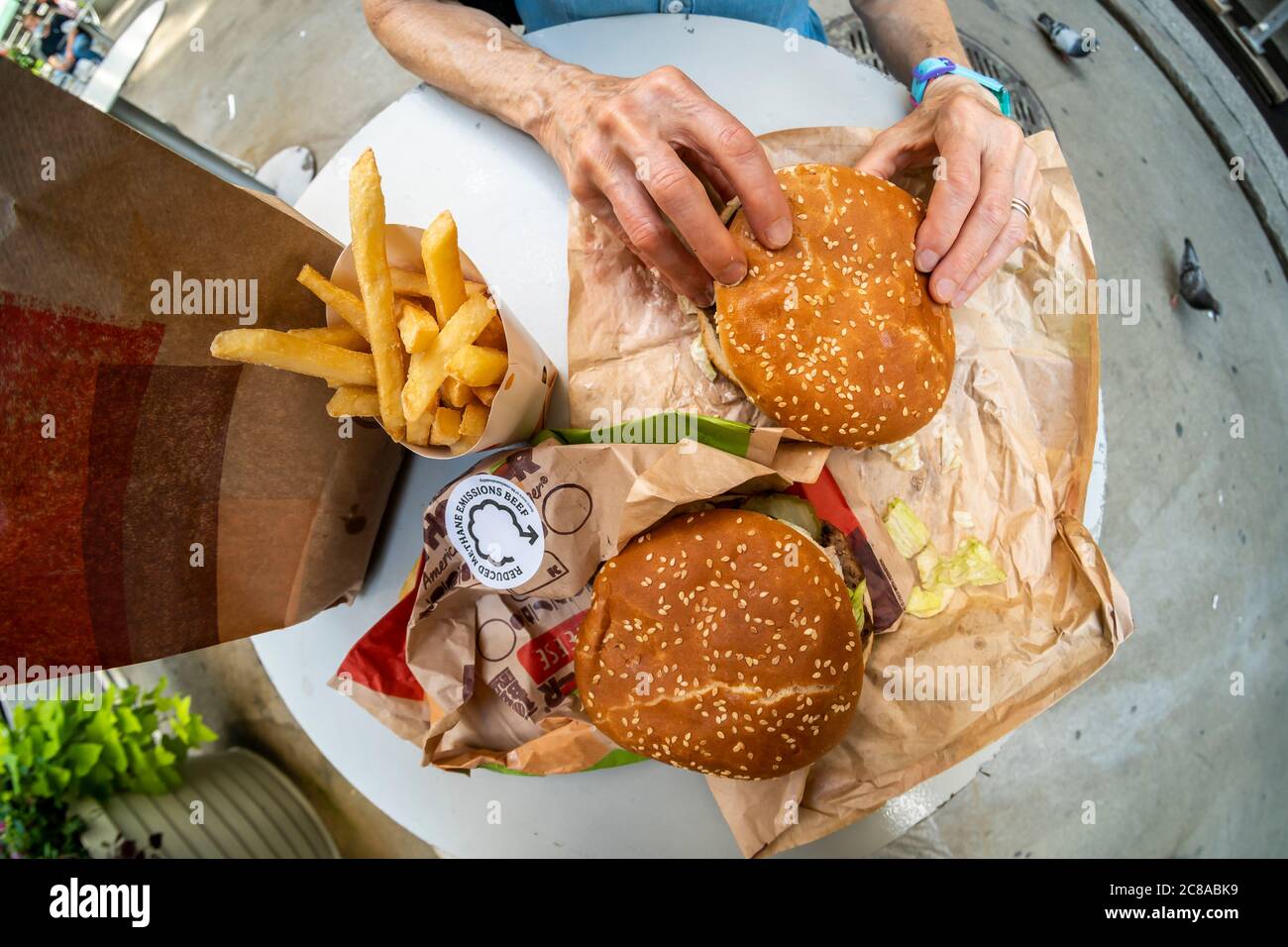 Ein Diner genießt einen Burger King reduziert Methanemissionen Beef Whopper in New York am Tag seiner Einführung, Dienstag, 14. Juli 2020. Die verringerte Methanemission Rindfleisch senkt die Menge an Methan von Kühen emittiert eine wichtige Quelle des Klimawandels. Die Kühe werden in ihrer Ernährung mit Zitronengras gefüttert, was die Emissionen um bis zu 33% reduziert. (© Richard B. Levine) Stockfoto