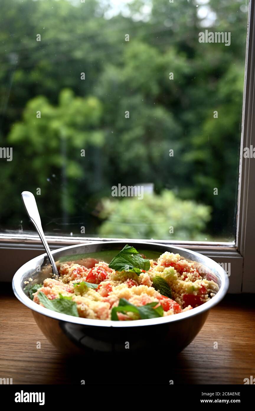 Vor einem Fenster. Couscous mit Minze, Tomaten, Zitrone und Olivenöl. Stockfoto