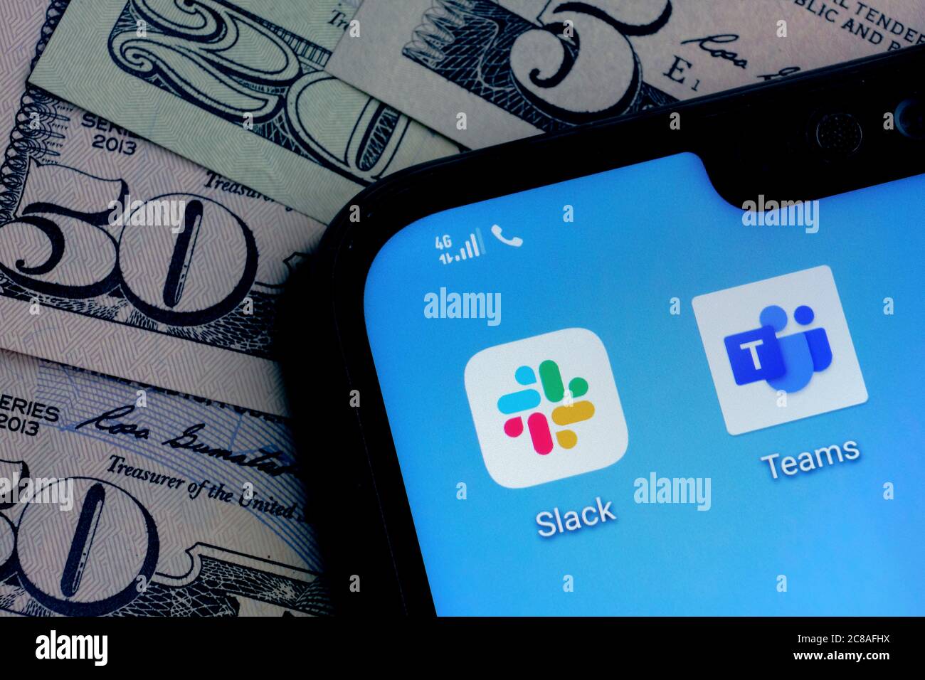 Stone / Großbritannien - Juli 22 2020: Slack und Microsoft Teams Apps auf der Ecke Smartphone-Bildschirm auf Dollarscheine Hintergrund platziert. Konzept für c Stockfoto
