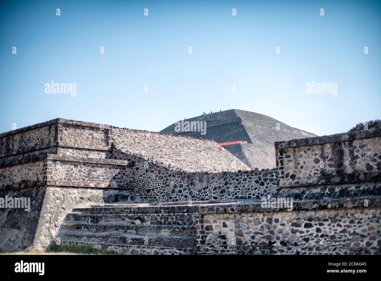 Pyramide der Sonne Teotihuacan Mexiko // TEOTIHUACAN, Mexiko — die kolossale Pyramide der Sonne dominiert die Landschaft an der archäologischen Stätte Teotihuacan. Dieses monumentale Gebäude, eine der größten antiken Pyramiden Amerikas, ist ein Zeugnis für die architektonischen und technischen Fähigkeiten dieser präkolumbischen Zivilisation. Die Pyramide erhebt sich etwa 216 Fuß (66 Meter) hoch und wurde um 200 n. Chr. während der klassischen Zeit der Stadt errichtet. Teotihuacan, was „der Ort, an dem die Götter erschaffen wurden“ in Nahuatl bedeutet, war eines der größten städtischen Zentren in der Antike Stockfoto