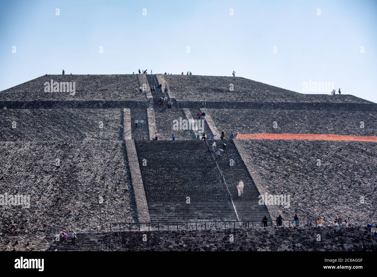 Pyramide der Sonne Besucher Teotihuacan Mexiko // TEOTIHUACAN, Mexiko — Besucher klettern die steilen Stufen der Pyramide der Sonne an der archäologischen Stätte Teotihuacan. Dieses monumentale Gebäude, eine der größten antiken Pyramiden Amerikas, erhebt sich etwa 216 Fuß (66 Meter) hoch und misst etwa 720 Fuß (220 Meter) an seiner Basis. Die Pyramide wurde um 100-450 n. Chr. von der antiken Teotihuacan-Zivilisation errichtet, deren Identität den Archäologen weitgehend unbekannt ist. Teotihuacan war eine der größten Städte in der Antike, mit einer Bevölkerung von bis zu zehn Stockfoto