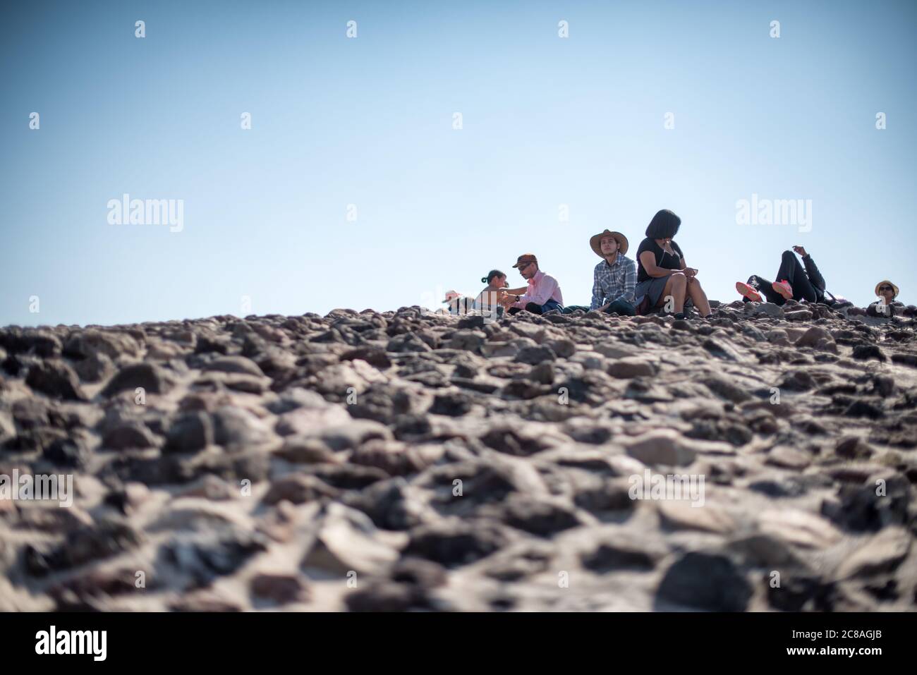 Pyramide der Sonne Besucher Teotihuacan Mexiko // TEOTIHUACAN, Mexiko — Besucher klettern die steilen Stufen der Pyramide der Sonne an der archäologischen Stätte Teotihuacan. Dieses monumentale Gebäude, eine der größten antiken Pyramiden Amerikas, erhebt sich etwa 216 Fuß (66 Meter) hoch und misst etwa 720 Fuß (220 Meter) an seiner Basis. Die Pyramide wurde um 100-450 n. Chr. von der antiken Teotihuacan-Zivilisation errichtet, deren Identität den Archäologen weitgehend unbekannt ist. Teotihuacan war eine der größten Städte in der Antike, mit einer Bevölkerung von bis zu zehn Stockfoto