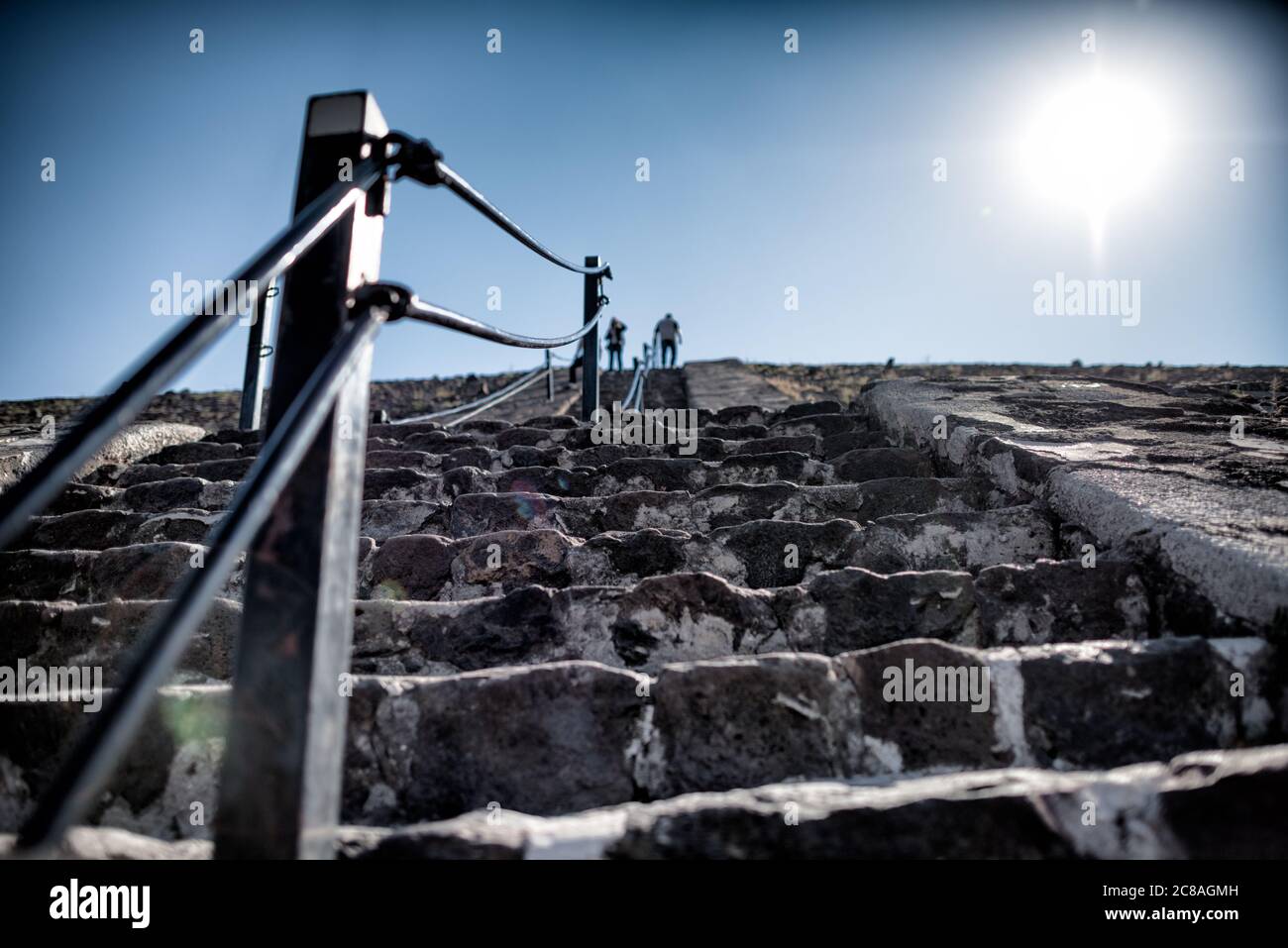 Pyramide der Sonne Schritte Teotihuacan Mexiko // TEOTIHUACAN, Mexiko – Besucher klettern die steilen Stufen der Pyramide der Sonne an der archäologischen Stätte Teotihuacan. Dieses monumentale Gebäude, eine der größten antiken Pyramiden Amerikas, erhebt sich etwa 216 Fuß (66 Meter) hoch und misst etwa 720 Fuß (220 Meter) an seiner Basis. Die Pyramide wurde um 100-450 n. Chr. von der antiken Teotihuacan-Zivilisation errichtet, deren Identität den Archäologen weitgehend unbekannt ist. Teotihuacan war eine der größten Städte in der Antike, mit einer Bevölkerung, die 100,0 erreicht haben könnte Stockfoto