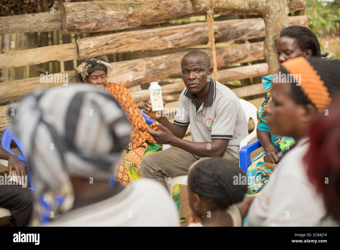 Ein Landarbeiter bildet Kleinbauern aus und verkauft sie bei einem Dorfgemeinden-Treffen im Kyotera District, Uganda. Stockfoto