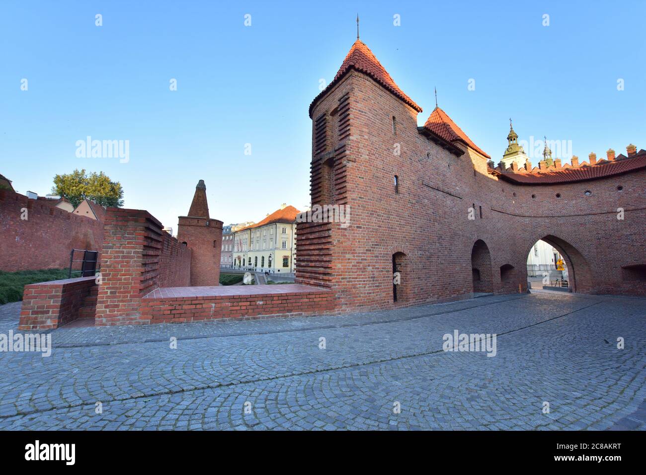 Der Barbican Tower in der Warschauer Altstadt im Licht der aufgehenden Sonne. Sommer. Stockfoto