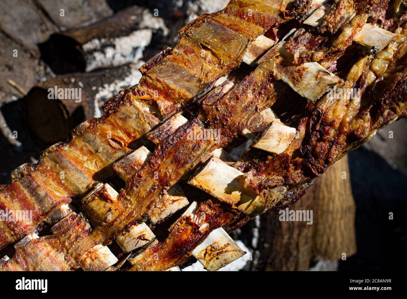 Asado, traditionelles Grillgericht in Argentinien, gebratenes Fleisch auf einem gekreuzten vertikalen Grills gekocht Stockfoto