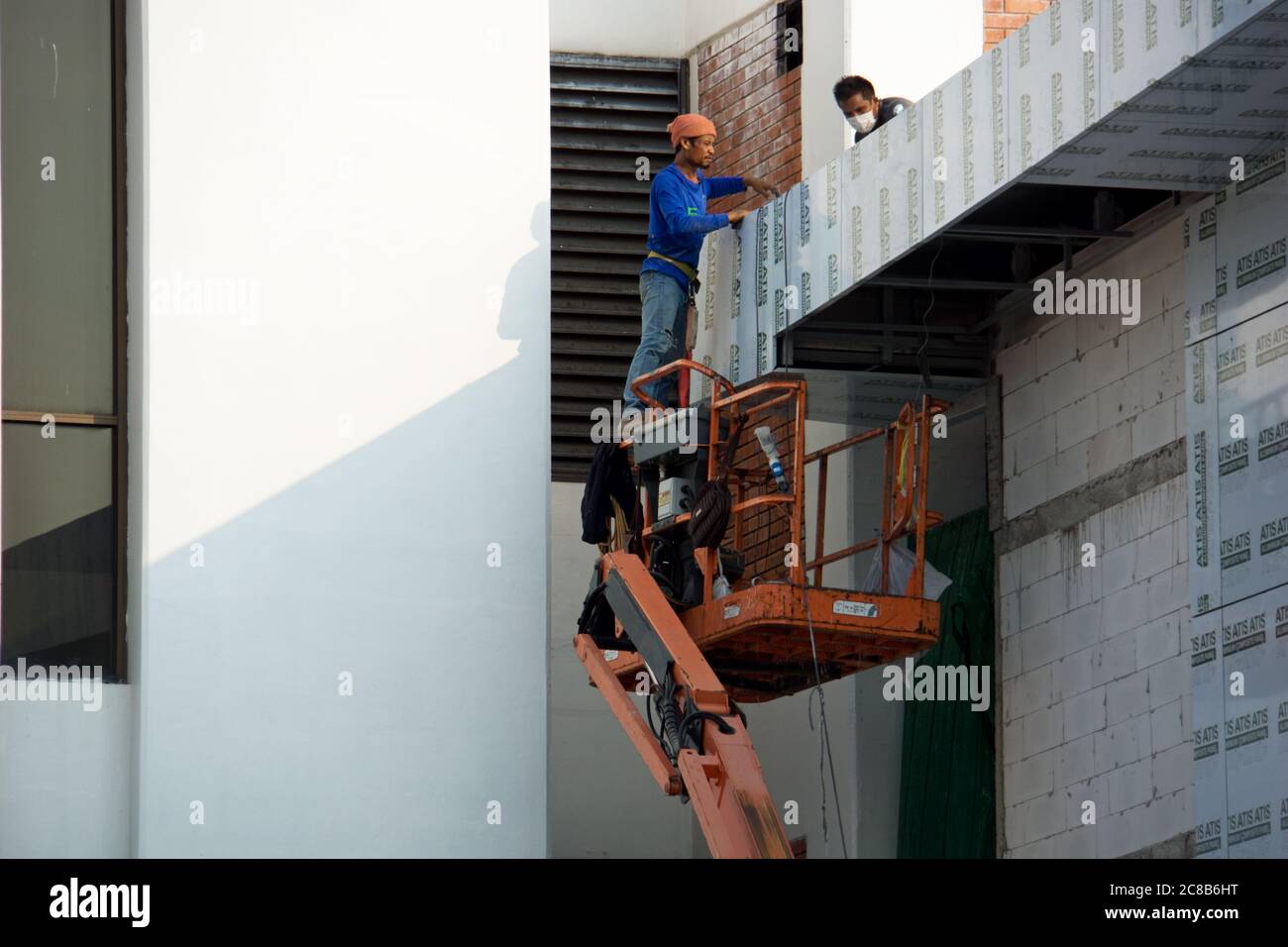 Thailand baut Bau Flughafen Sanierung mit Scherenlift und Thai Arbeiter Montage Paneele an den Flughafenwänden tagsüber in Bangkok, Thailand. Stockfoto