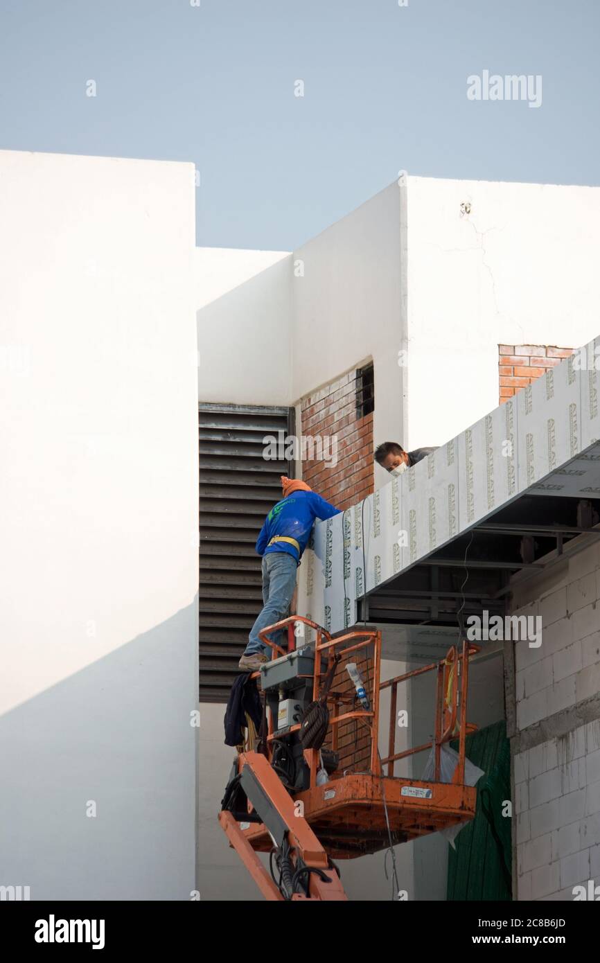 Thailand baut Bau Flughafen Sanierung mit Scherenlift und Thai Arbeiter Montage Paneele an den Flughafenwänden tagsüber in Bangkok, Thailand. Stockfoto