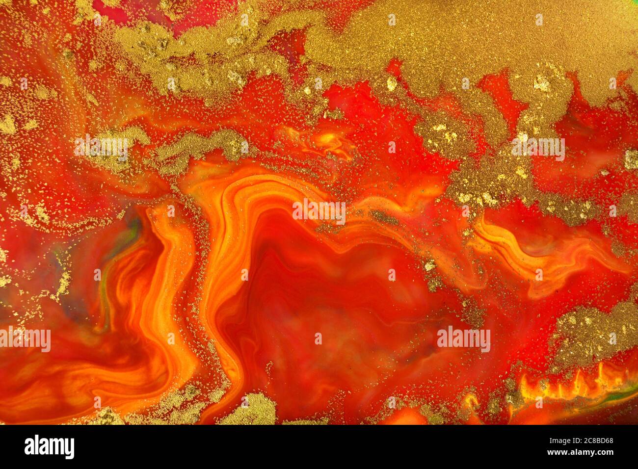 Rot und gelb Fluidmuster mit Goldpartikeln Stockfoto