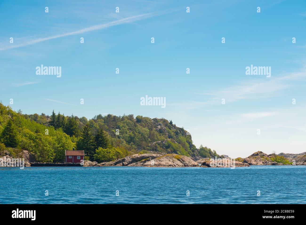 Ein kleines rotes Bootshaus auf einer Insel im Sommer. Stockfoto