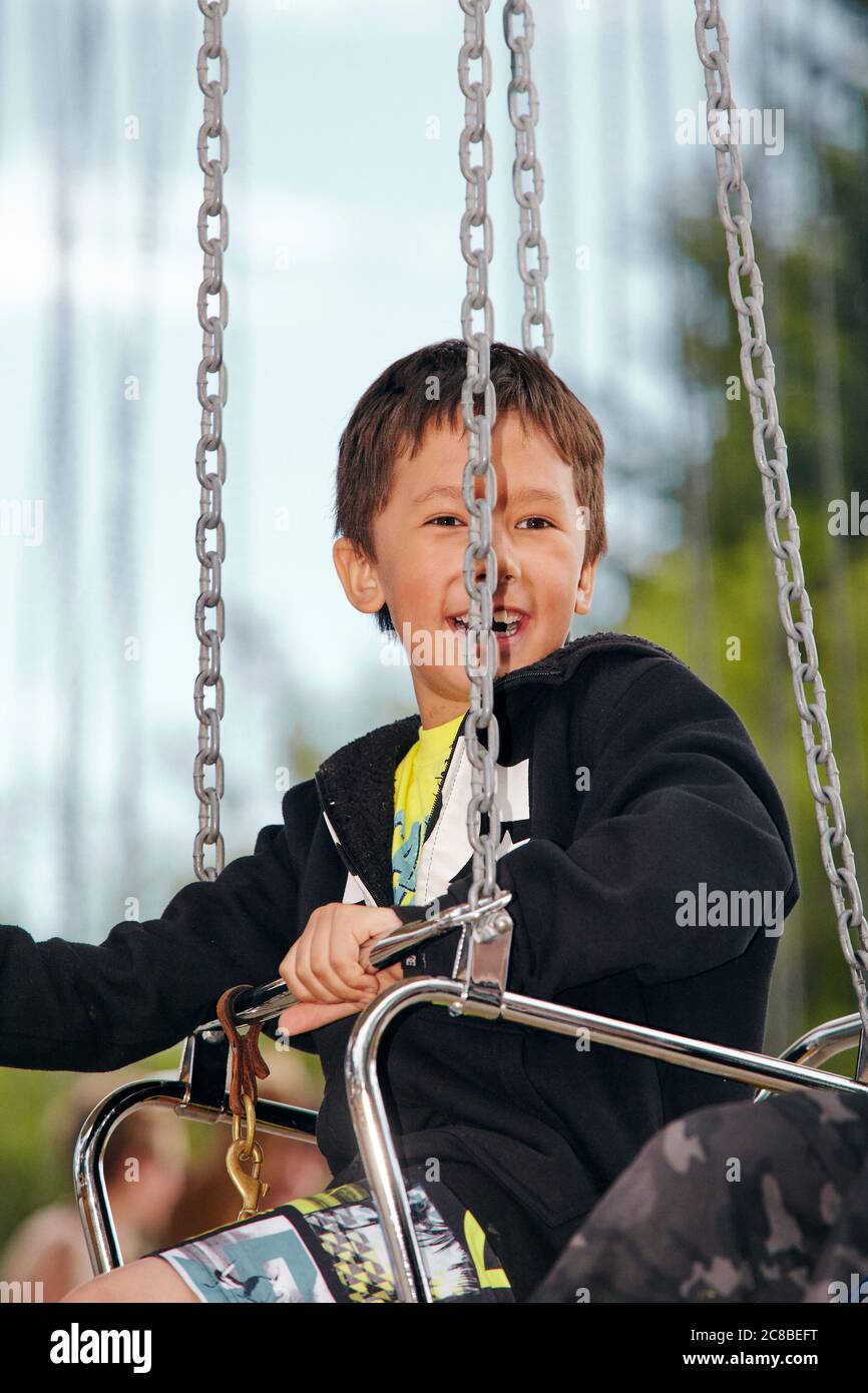 Kinder genießen die Fahrt auf einem Karussell an einem sonnigen Nachmittag im Heritage Park in Calgary, Alberta Stockfoto