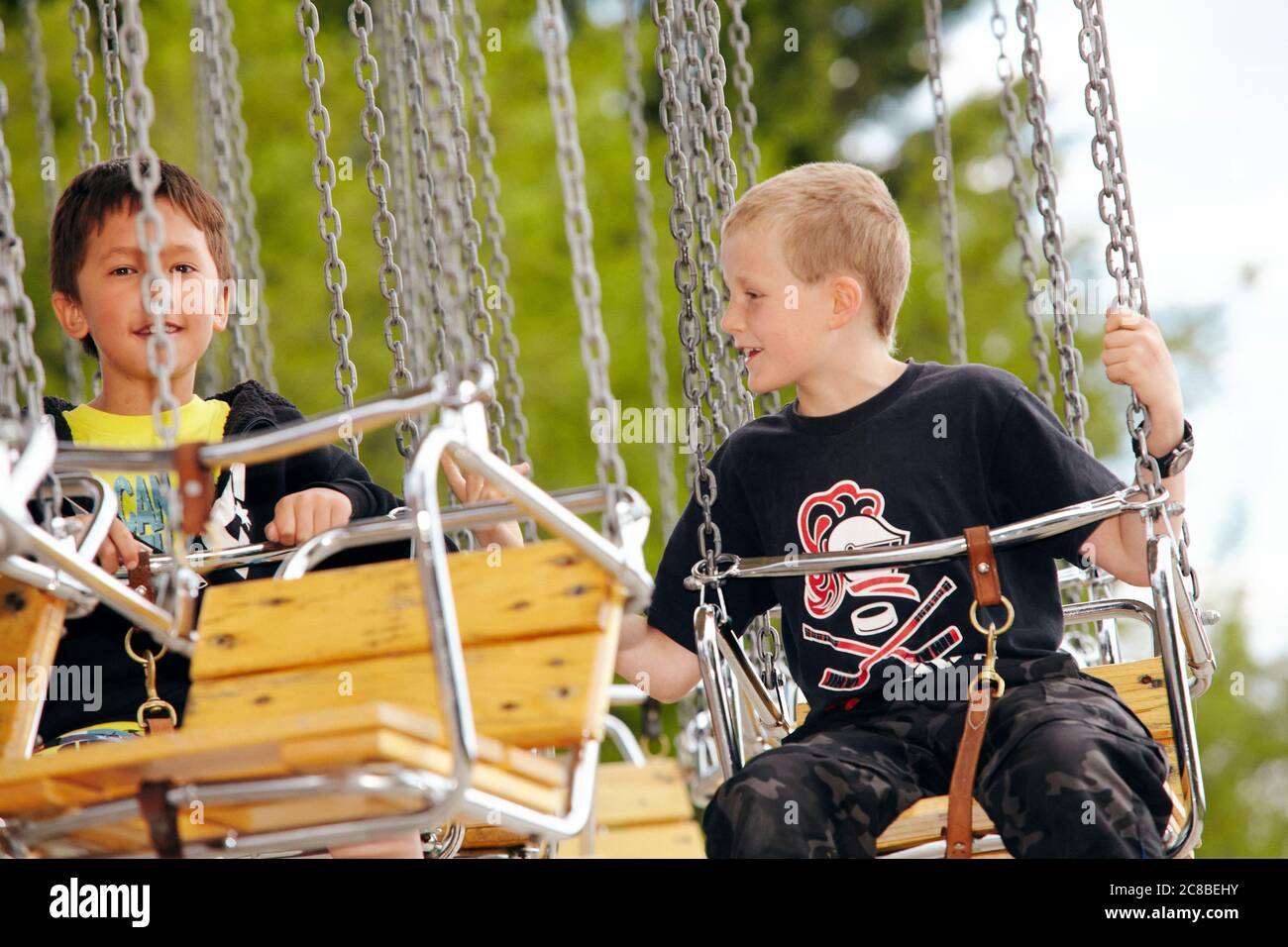 Kinder genießen die Fahrt auf einem Karussell an einem sonnigen Nachmittag im Heritage Park in Calgary, Alberta Stockfoto