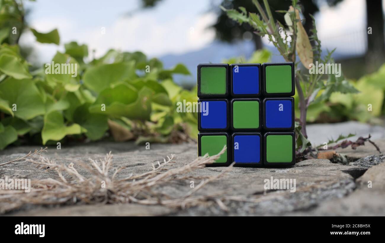 Rubik's Würfel auf einem Schreibtisch und einem grünen natürlichen Hintergrund entlang der venezianischen Wände, Bergamo. Rubik's Cube erfunden von einem ungarischen Architekten Erno Rubik Stockfoto