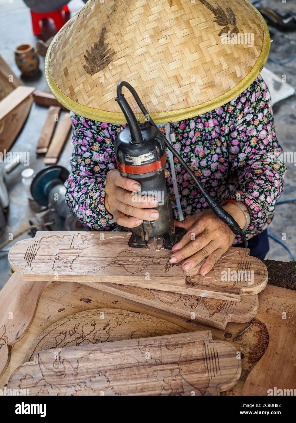 Vietnamesische Frau in Hut Dekoration Holzmöbel. Hanoi, Vietnam, 23. März 2017. Stockfoto