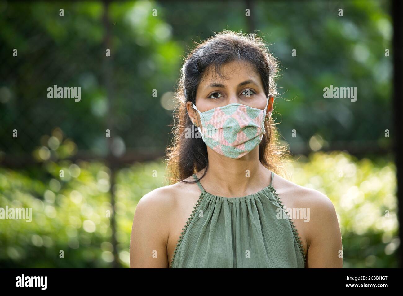 Frau mit Schutzmaske im Park Stockfoto