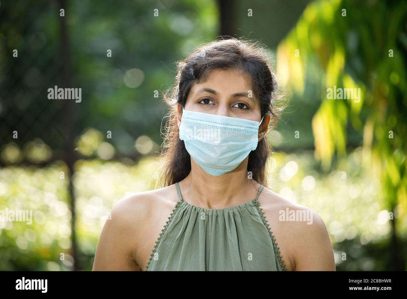 Frau mit Schutzmaske im Park Stockfoto