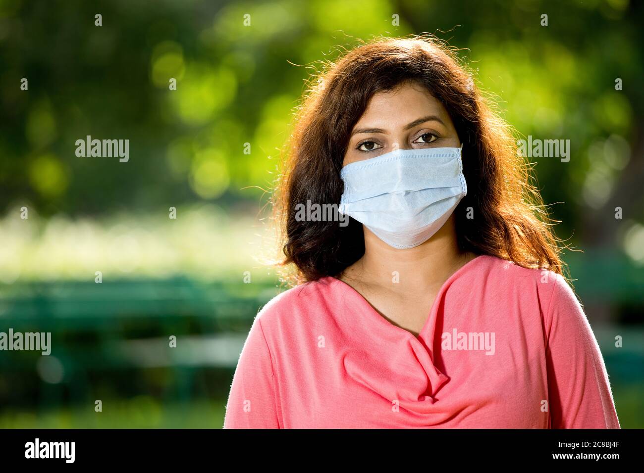 Frau mit Schutzmaske im Park Stockfoto