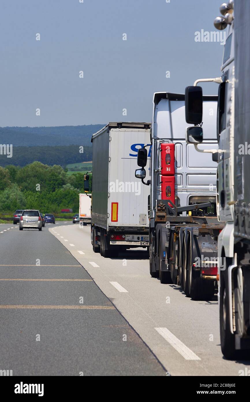 Kilometerlange Schlange, unzählige kommerzielle Lastwagen, die auf der deutschen Autobahn rasierten. Stockfoto