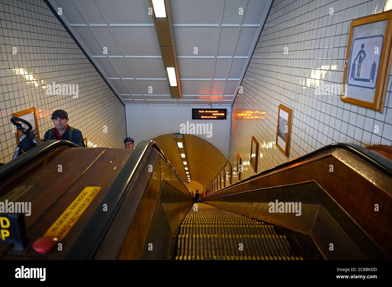 antwerpen, belgien - 2020.07.14: Menschen mit ihren Fahrrädern auf der Rolltreppe des rechten scheldtbänke Eingang des st anna Fußgängertunnels von 1933 bei sint- Stockfoto