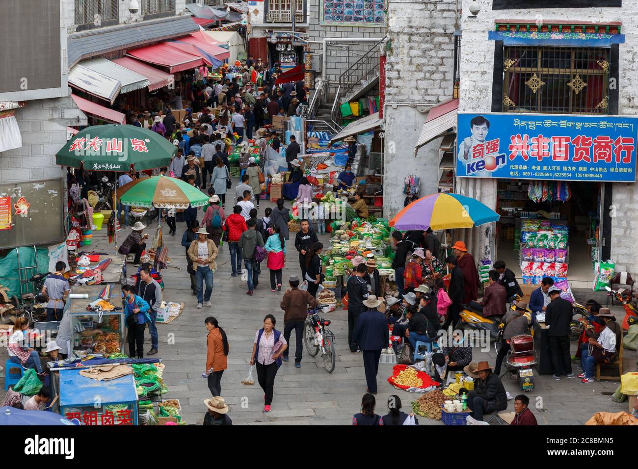 Lhasa, Tibet / China - 29. Jul 2017: Blick auf den überfüllten Straßenmarkt in einer Gasse der tibetischen Hauptstadt Lhasa. Menschen einkaufen, Stände mit Gemüse und f Stockfoto
