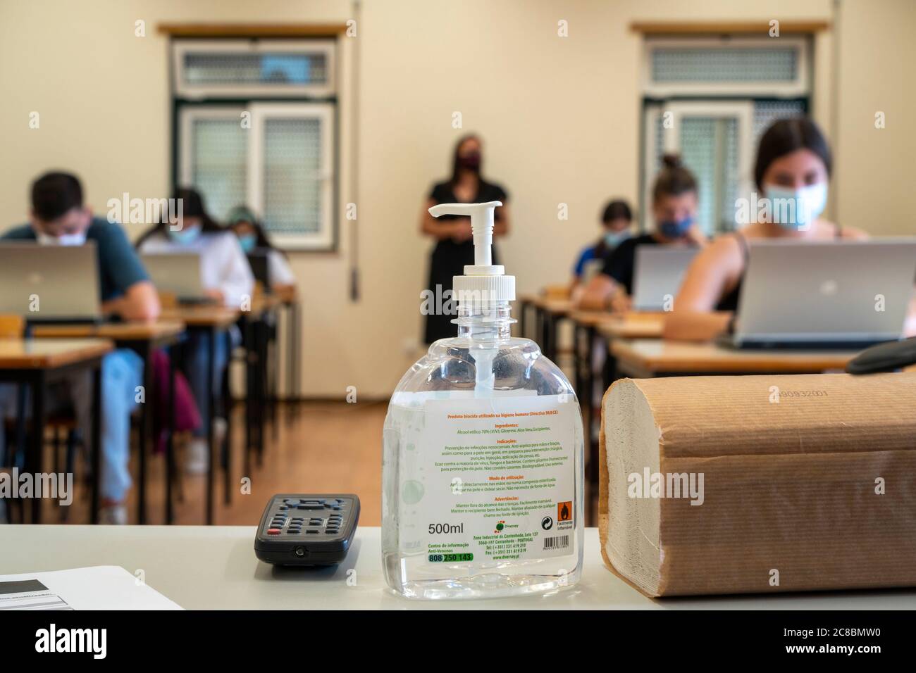 Flasche Handdesinfektionsmittel vor den Schülern, die Gesichtsmasken während der neuartigen Coronavirus COVID-19 Pandemie tragen Stockfoto