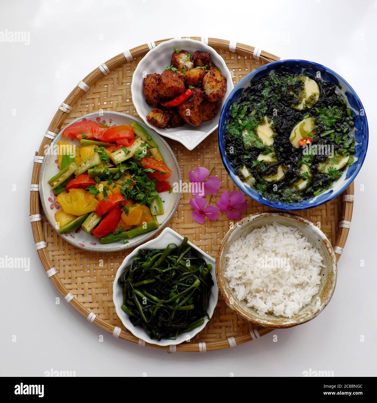 Vietnamesische vegane Küche, tägliches Familienessen zum Mittagessen, Abendessen, Algensuppe, Tofu, gebratenes Gemüse, getrocknetes Brot kochen mit Sauce, gekochtes Wasser Spinat Stockfoto