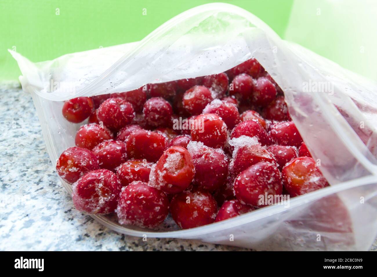 Gefrorene Kirschen in einem offenen Plastikbeutel von etwas oben Stockfoto