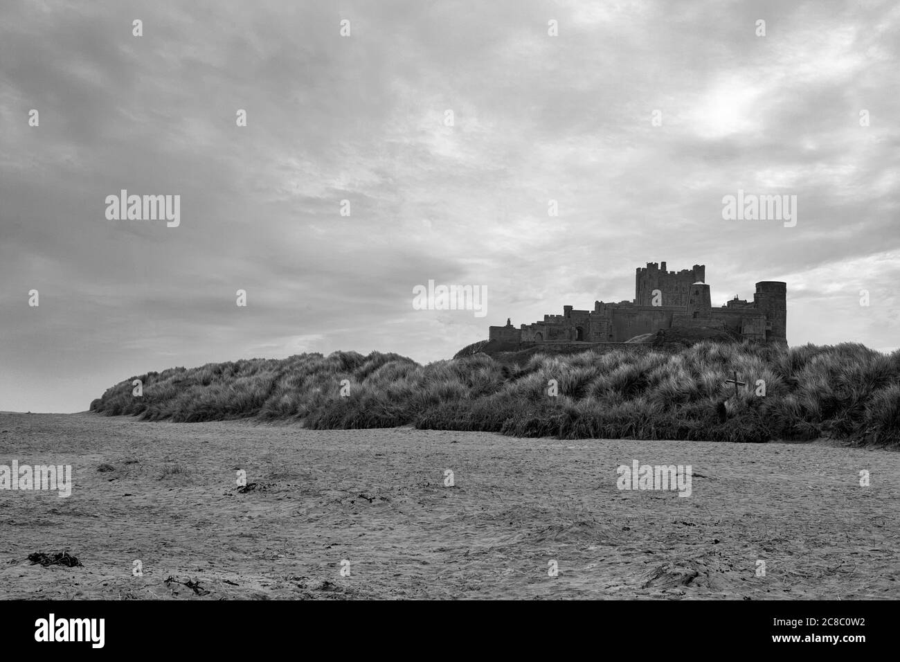 Bamburgh Castle, Northumberland, England, Großbritannien, gegenüber dem Sandstrand von Bamburgh Beach. Schwarz-Weiß-Version Stockfoto