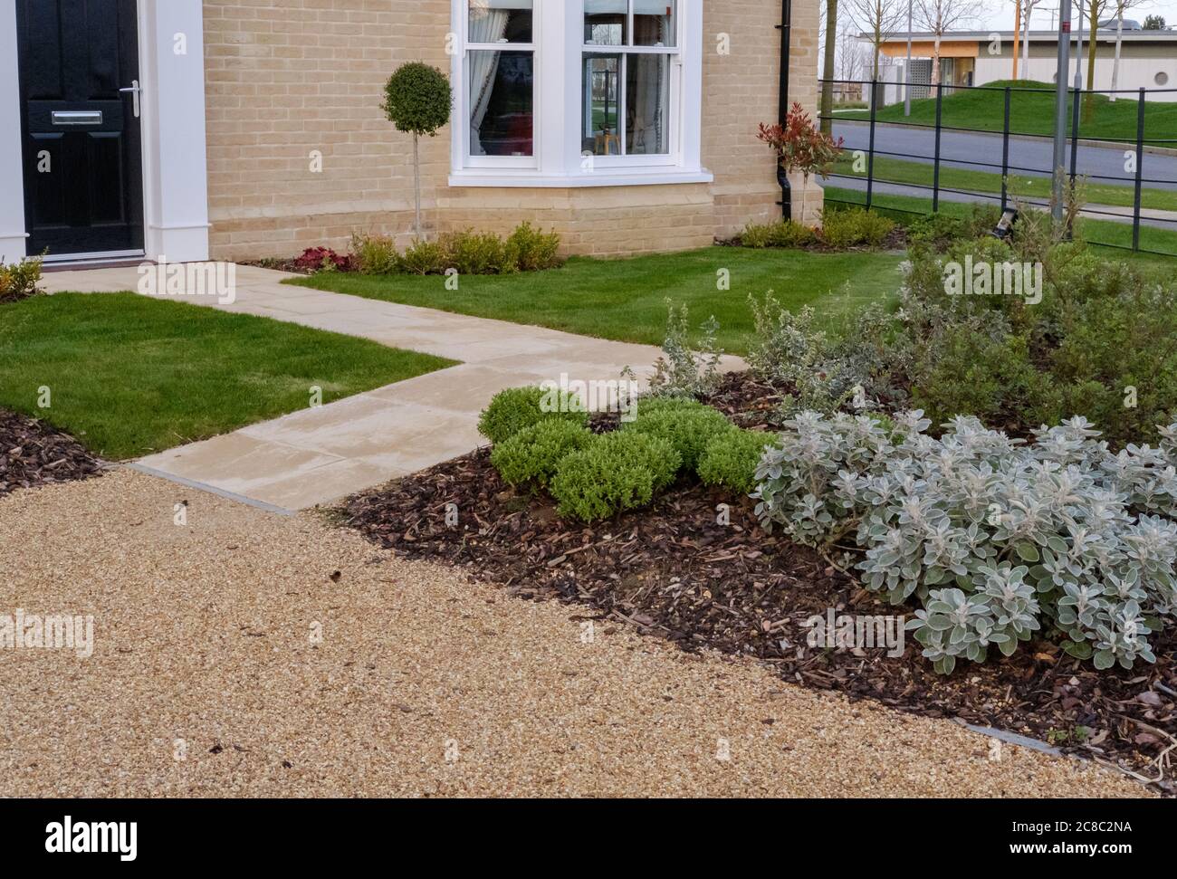 Gut gepflegter und landschaftlich gestalteter Garten, der in einem modernen, neu erbauten Showhaus am Eingang zu einer neuen Wohnsiedlung in Großbritannien zu sehen ist. Stockfoto