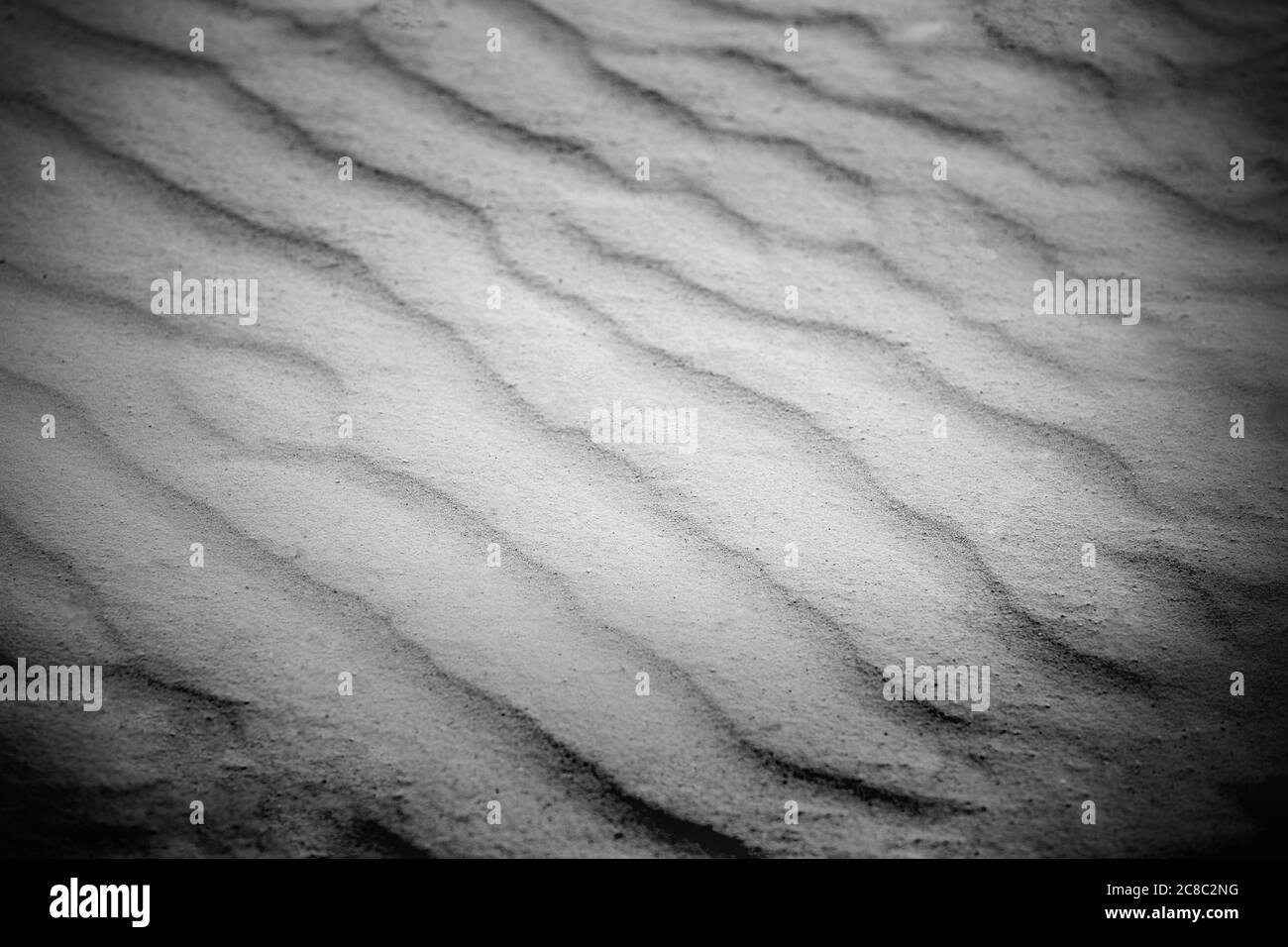 Wellige Textur aus weißem Sand, der im Wind weht. Hintergrund von weißem Sand Natur Textur Stockfoto