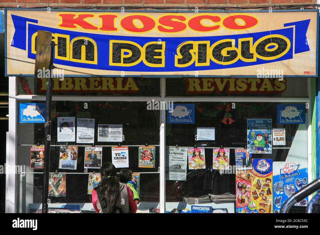 Indigene Frau und ihr Baby checken die Zeitschriften in einer Buchhandlung in Rio Gallegos, Südargentinien. Stockfoto
