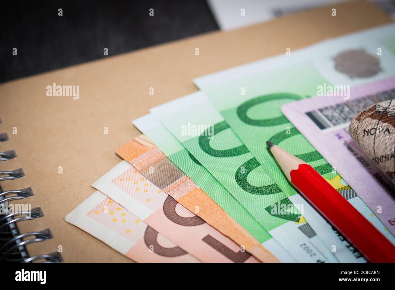 Euro-banknoten auf Notepad. Das Geld wird auf das Handwerk Notepad, mit roten Bleistift und Führerschein. Stockfoto