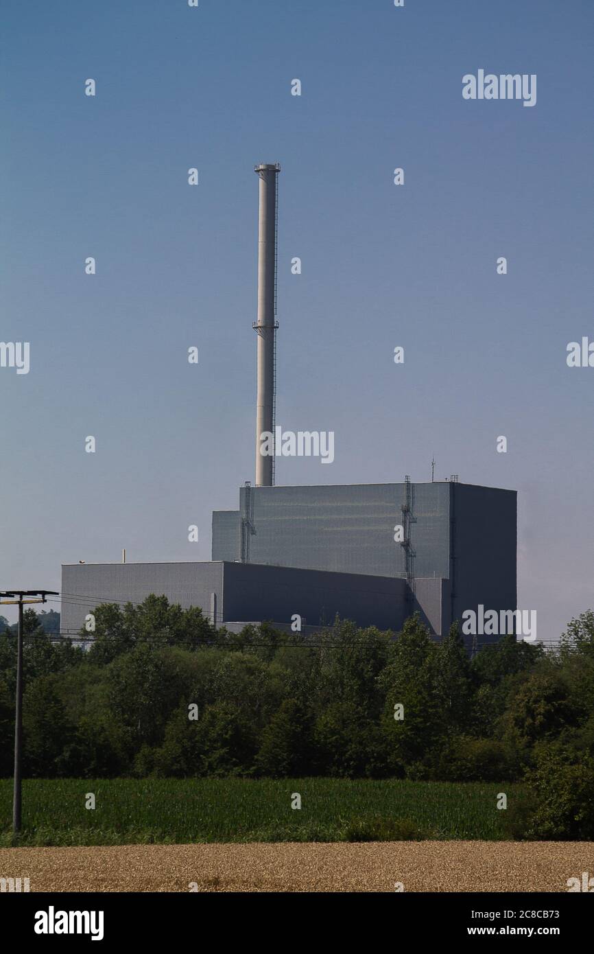 Das Maschinenhaus mit den Dampfturbinen eines Kernkraftwerks. Und dahinter ein Kamin. Stockfoto