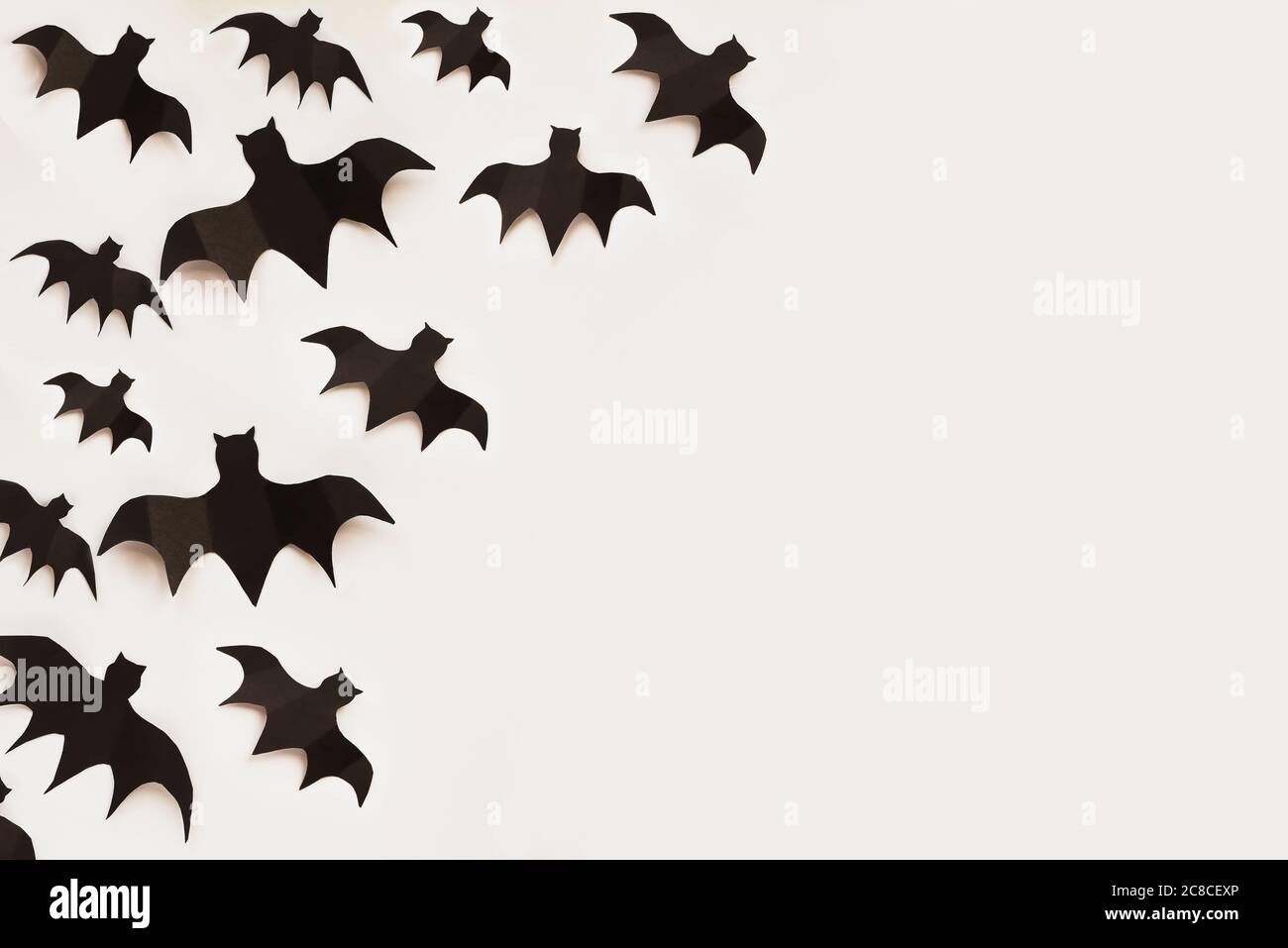 Halloween Feiertagsdekorationen von vielen Papierfledermäusen fliegen über einen leeren weißen Hintergrund mit freiem Platz für Text. Draufsicht. Stockfoto