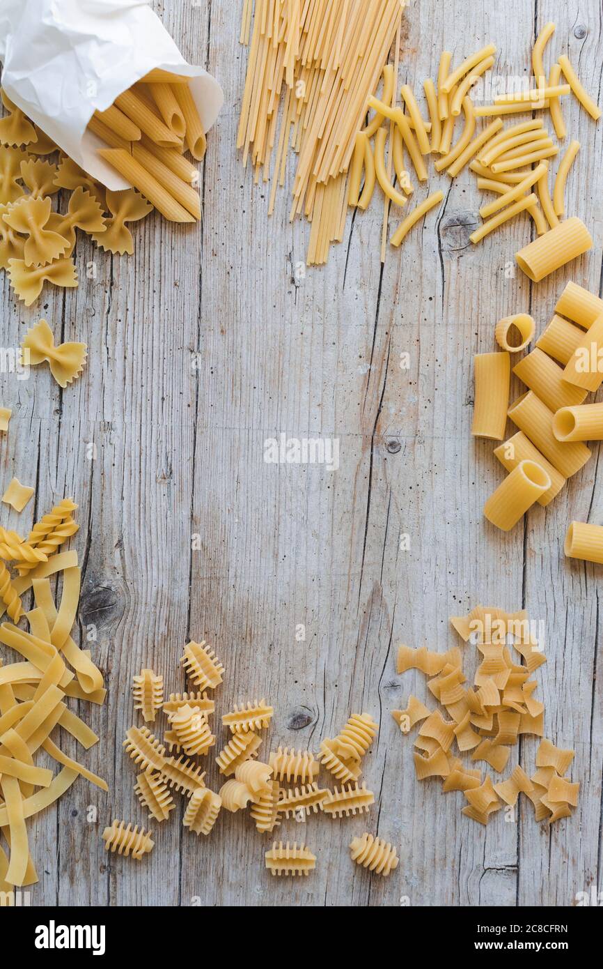 Verschiedene Arten von Eiernudeln und gelbe Pasta auf Holzgrund Stockfoto