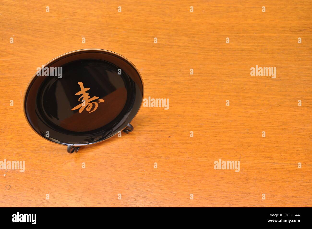 Dekorative Platte aus schwarzem Porzellan mit einem Buchstaben des japanischen Alphabets, auf einem Sockel, Draufsicht, Kopierraum, Brasilien, Südamerika Stockfoto